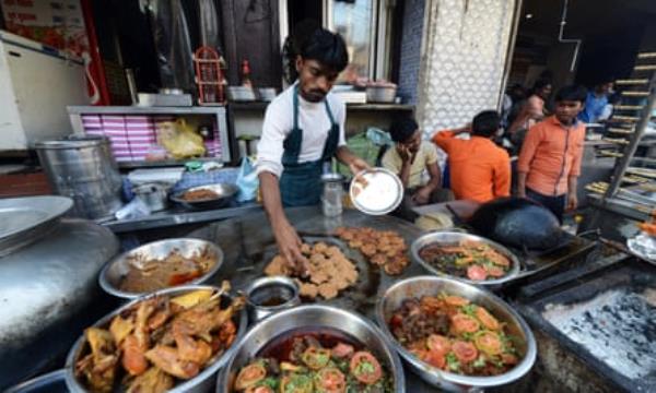 A vendor prepares traditional minced kebabs